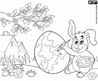 Όλα έτοιμα για την άφιξη του Πάσχα, ένα κουνέλι που ζωγραφίζει ένα αυγό του Πάσχα